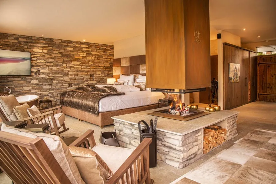 Wohnbereich mit offenem Kamin und einem großen Bett im Golden Hill