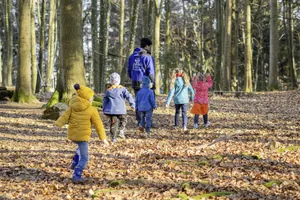 Gruppe von Kindern mit Betreuer beim Wald-Erlebnisprogramm des Kinderhotels