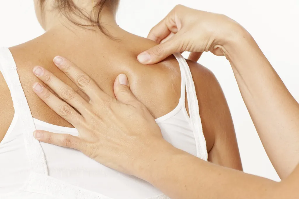 Eine Frau wird am Nacken osteopathisch behandelt