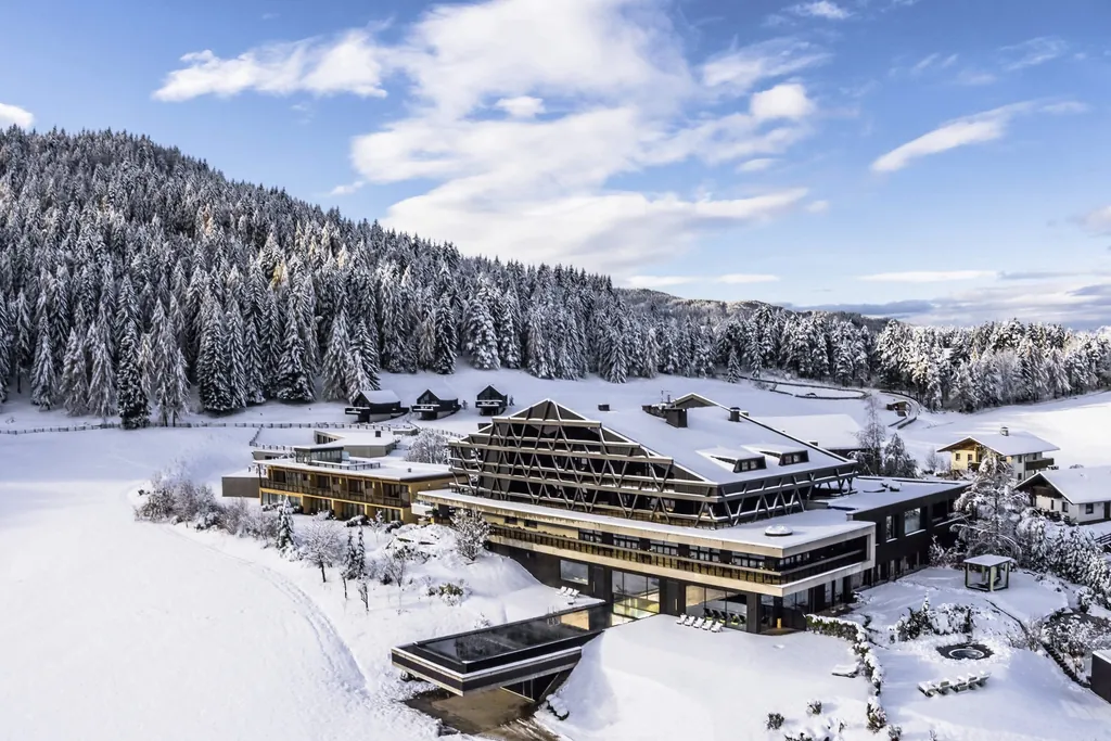 Naturhotel Pfösl im Schnee von oben mit Blick auf die Fassade und den Pool
