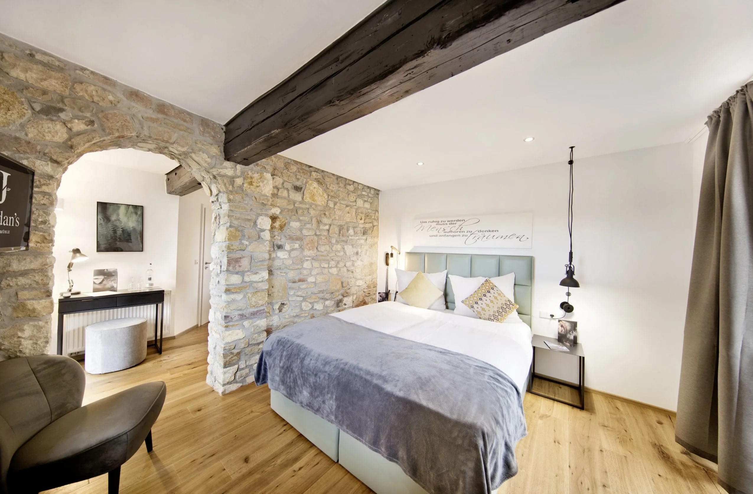 Doppelzimmer im Weinhotel Jordan&rsquo;s Unterm&uuml;hle mit historischen Mauerelementen und Holzbalken