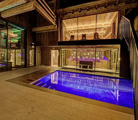 Blick auf Pooleinstieg und verschiedene Saunen bei Nacht in der Andreus Golf Lodge