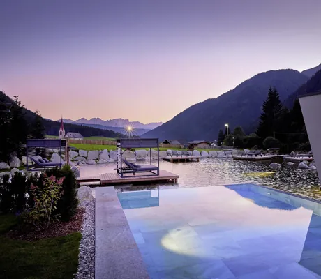Außenpool und Naturbadeteich mit Daybeds im Wellnesshotel Fontis luxury spa lodge