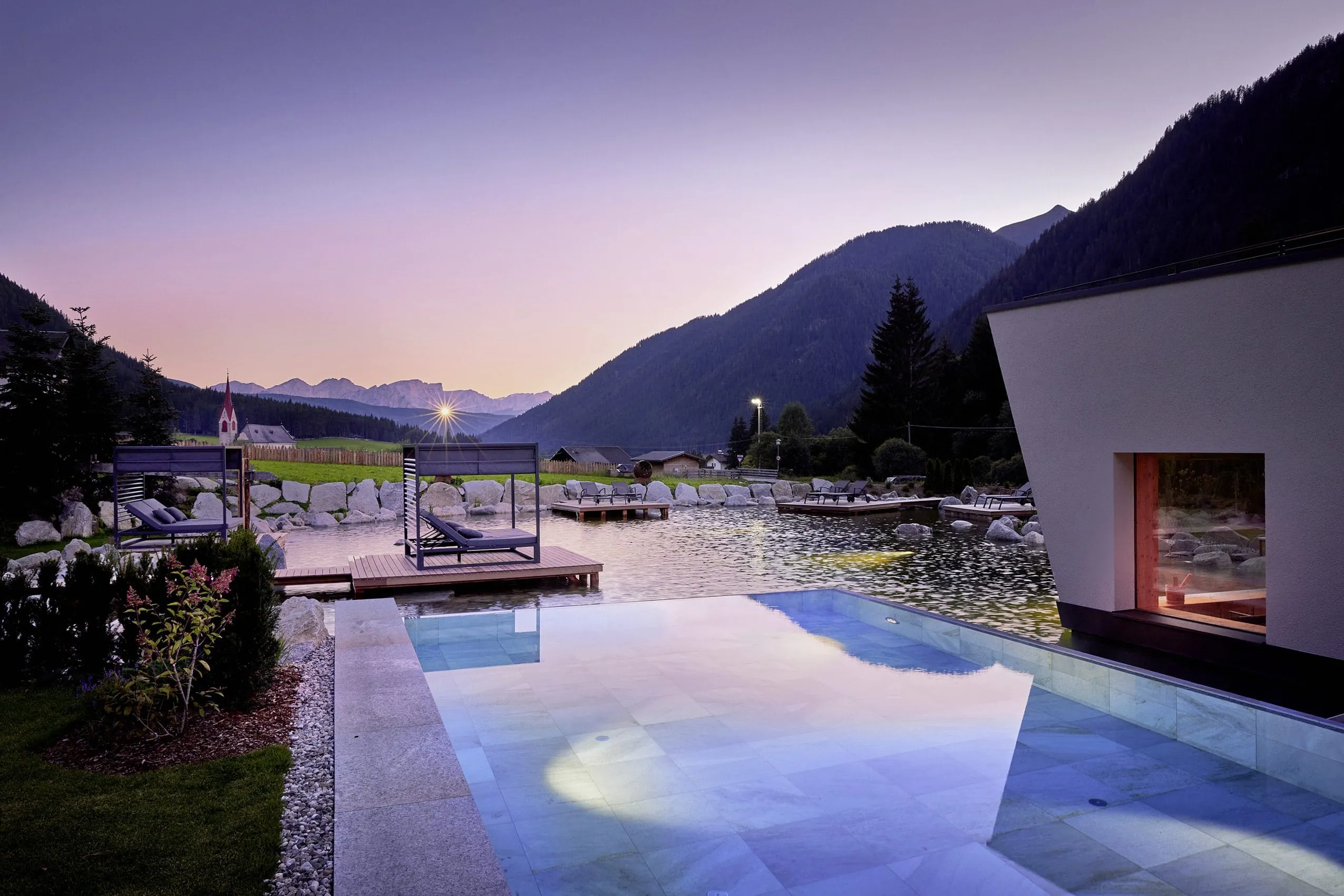 Außenpool und Naturbadeteich mit Daybeds im Wellnesshotel Fontis luxury spa lodge