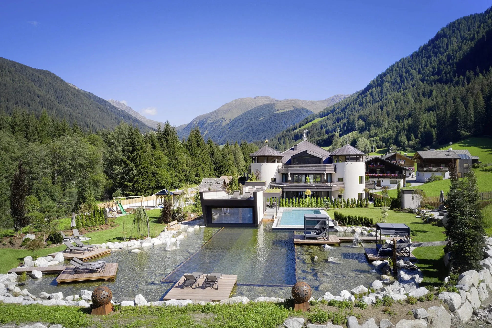 Gesamtansicht des Wellnesshotels Fontis luxury spa lodge mit Naturbadeteich und Outdoorpool