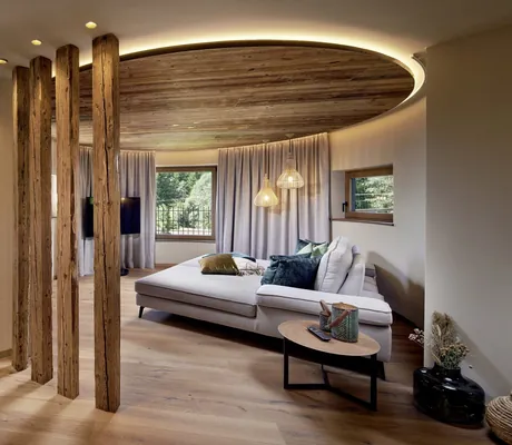 Doppelbett unter runder Deckenbeleuchtung im Wellnesshotel Fontis luxury spa lodge