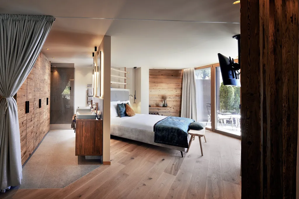 Suite mit Doppelbett und Trennwand zum Bad im Wellnesshotel Fontis luxury spa lodge