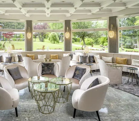 Stylischer Wintergarten mit gemütlichen Sesseln und Blick in den Hotelpark im Parkhotel Adler