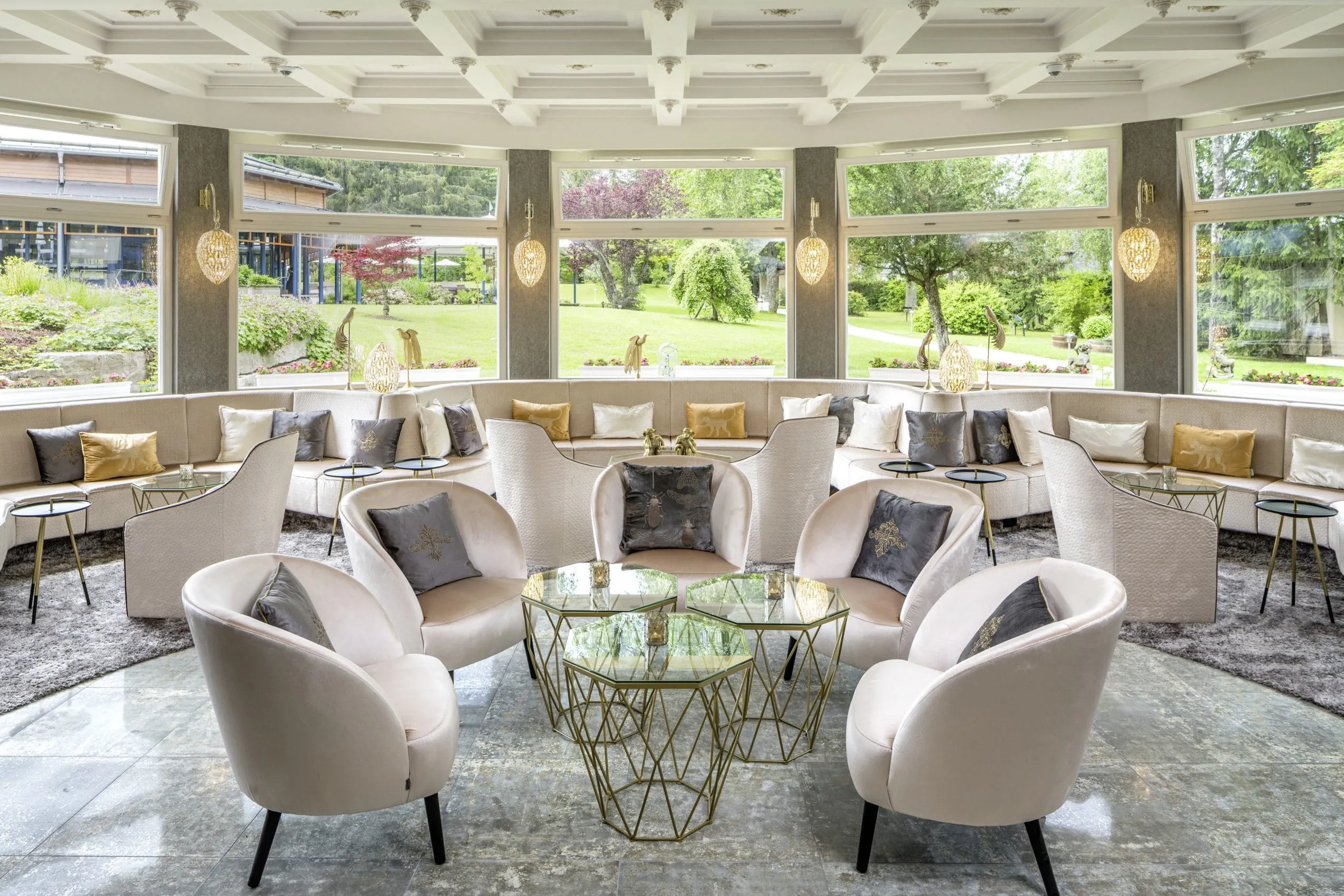 Stylischer Wintergarten mit gem&uuml;tlichen Sesseln und Blick in den Hotelpark im Parkhotel Adler