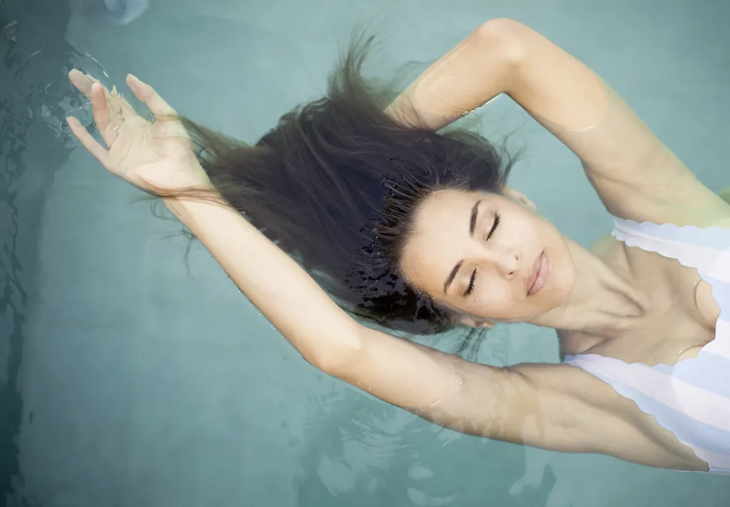 Badende Frau mit geschlossenen Augen im PURMONTES Private Luxury Chalet in Südtirol