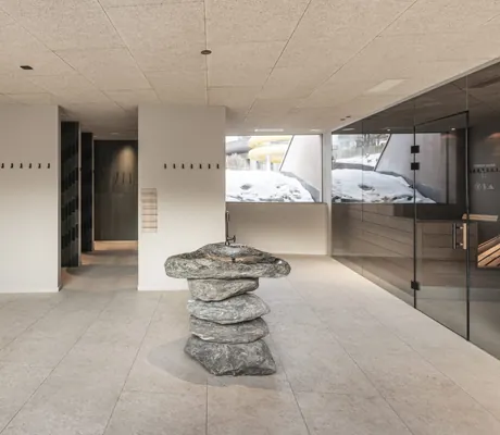 Lobby im modern gestalteten Wellnessbereich mit Türen zu verschiedenen Saunen und Trinkbrunnen