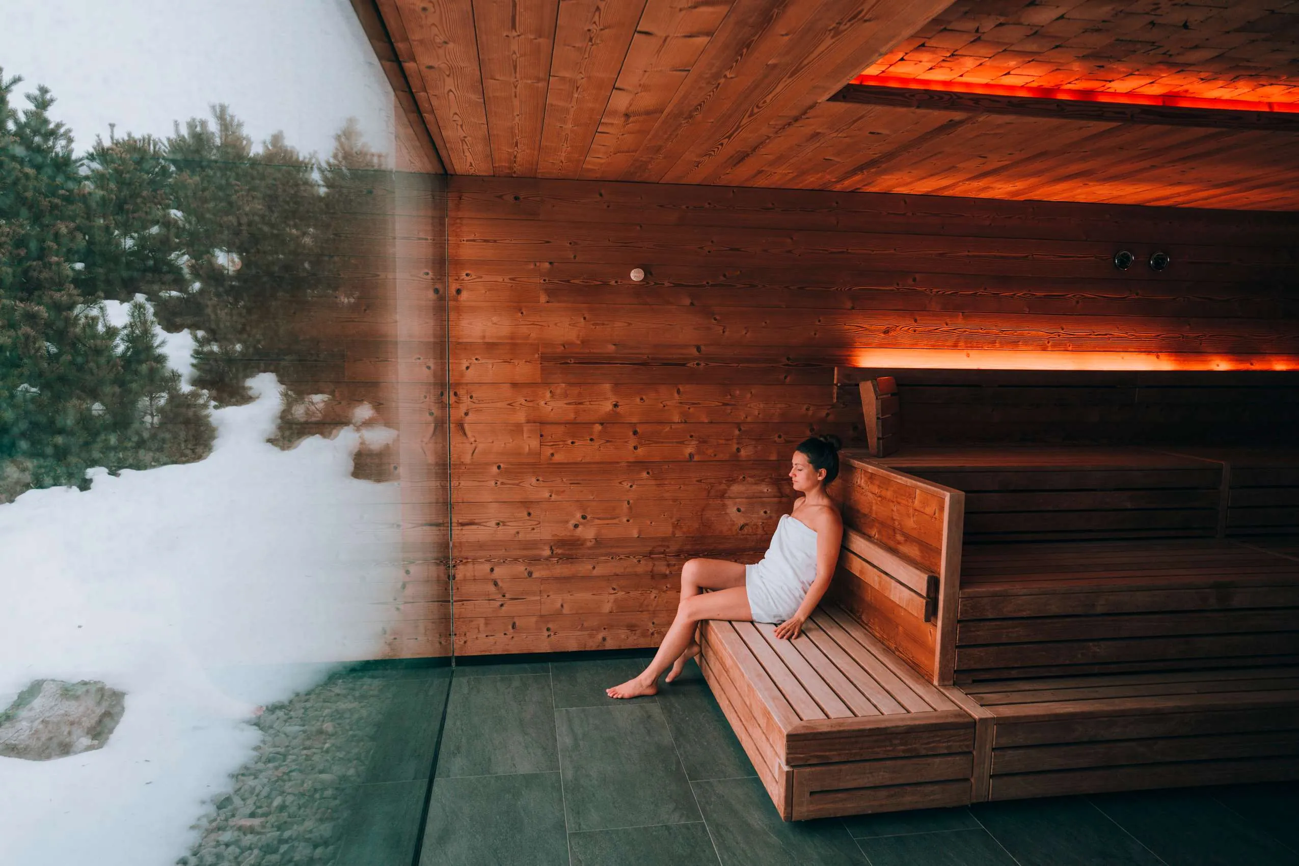 Junge Frau in Panoramasauna im Wellnessbereich des Naturresort PURADIES