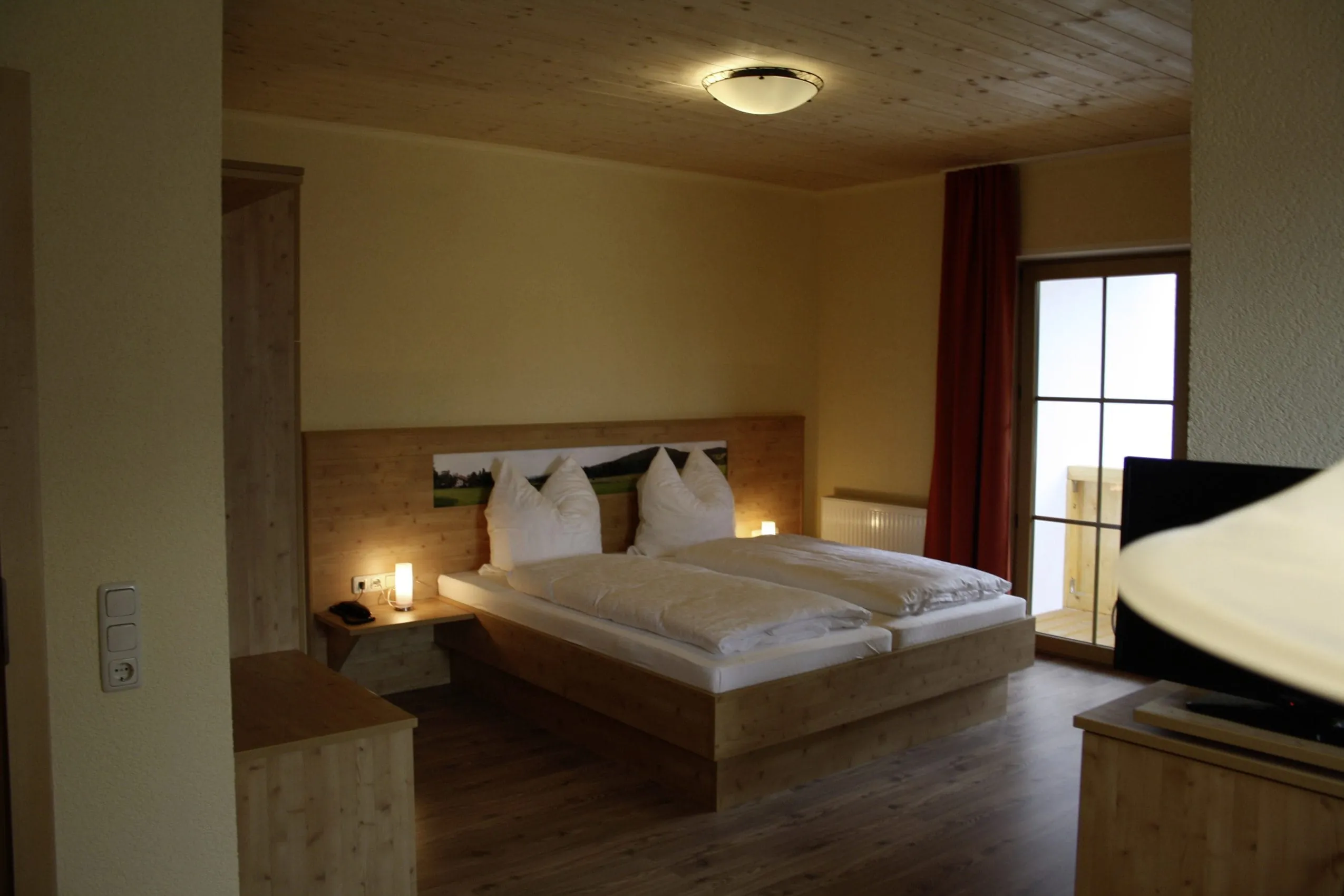 Doppelzimmer mit Vorhang und Fernseher im Hotel B&auml;renhof