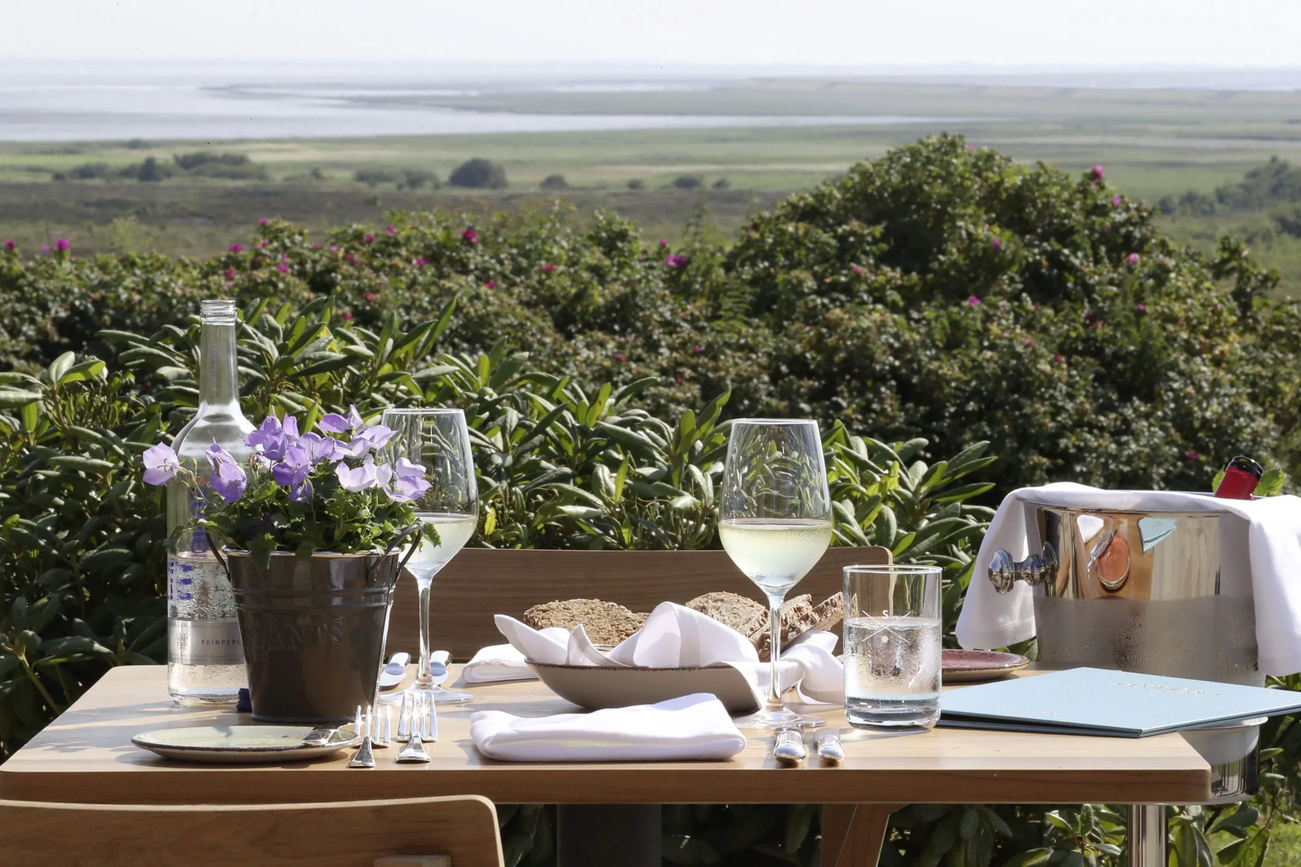 Gedeckter Tisch auf der Terrasse des Landhaus Severins Morsum Kliff mit Blick auf die D&uuml;nen und das Meer