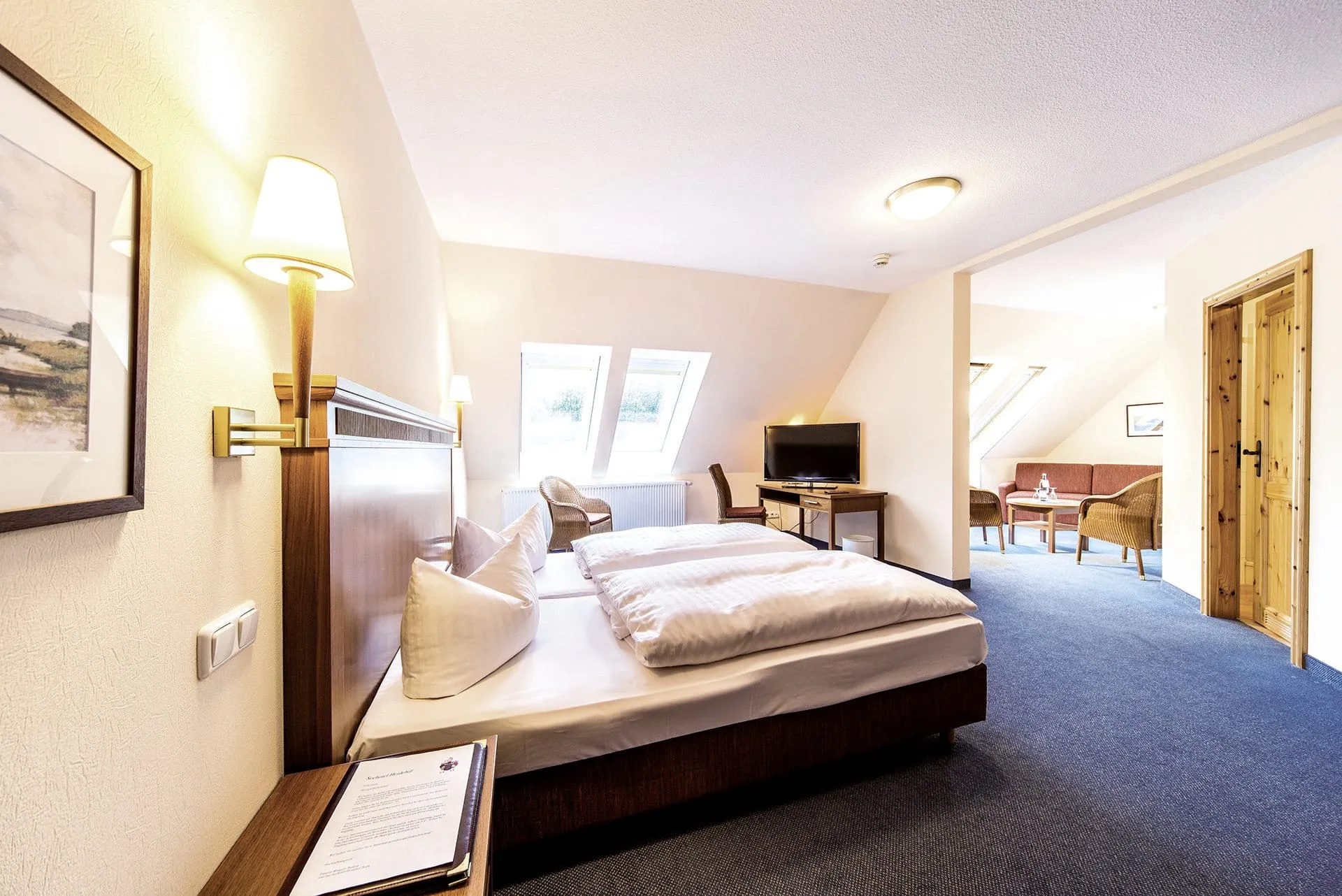 Doppelzimmer mit Bett, Sofa und Fernseher im Hundehotel Seehotel Heidehof