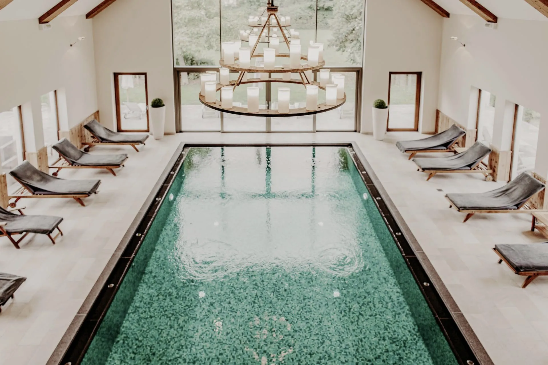 Pool mit Kronleuchter und Liegen im Hotel Der Eisvogel