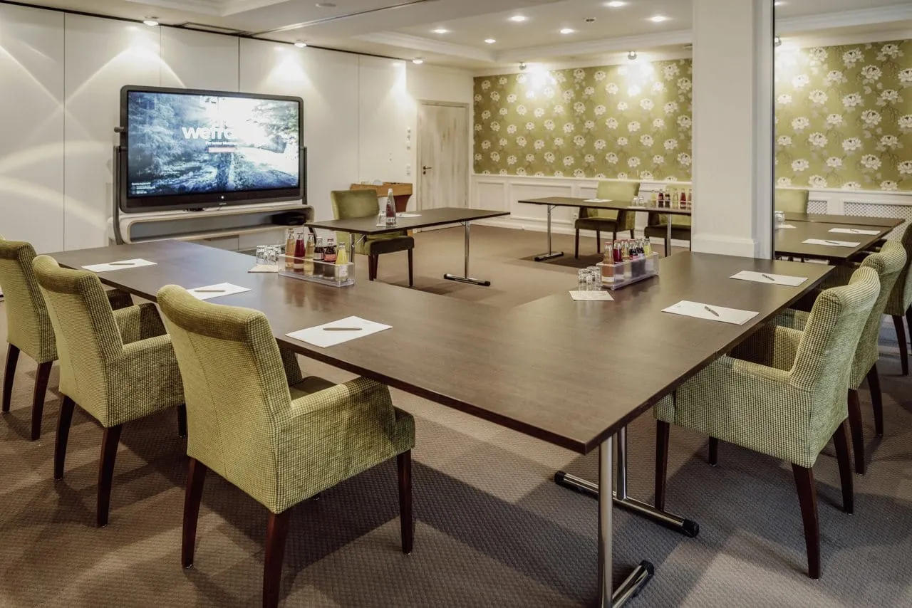 Bestuhlter Tagungsraum mit bunter Tapete