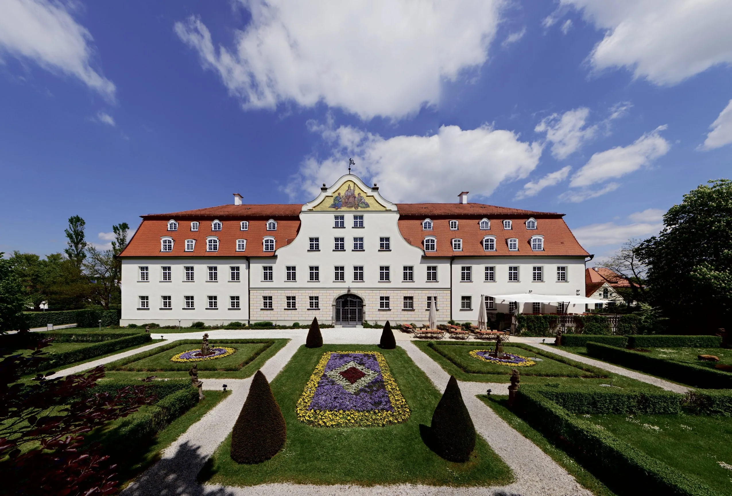 Au&szlig;enansicht des Schloss Lautrach mit bl&uuml;hender Parkanlage