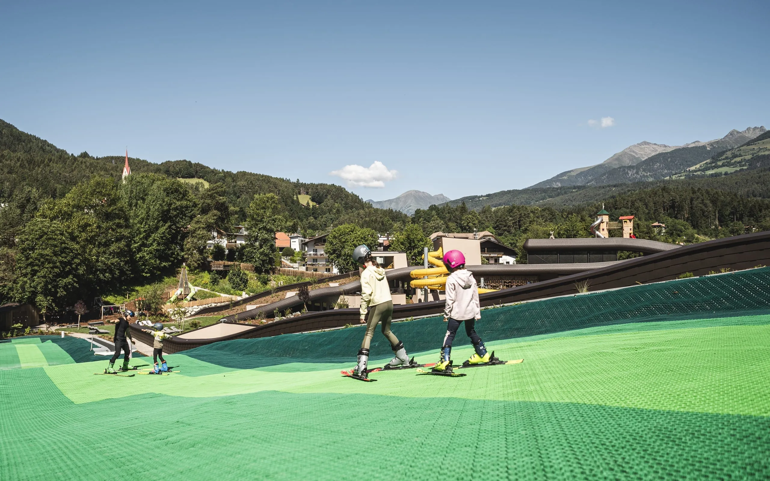 Einige Kinder trainieren auf dem Rooftop Sky Adventure Park des Falkensteiner Family Resort Lido Skifahren