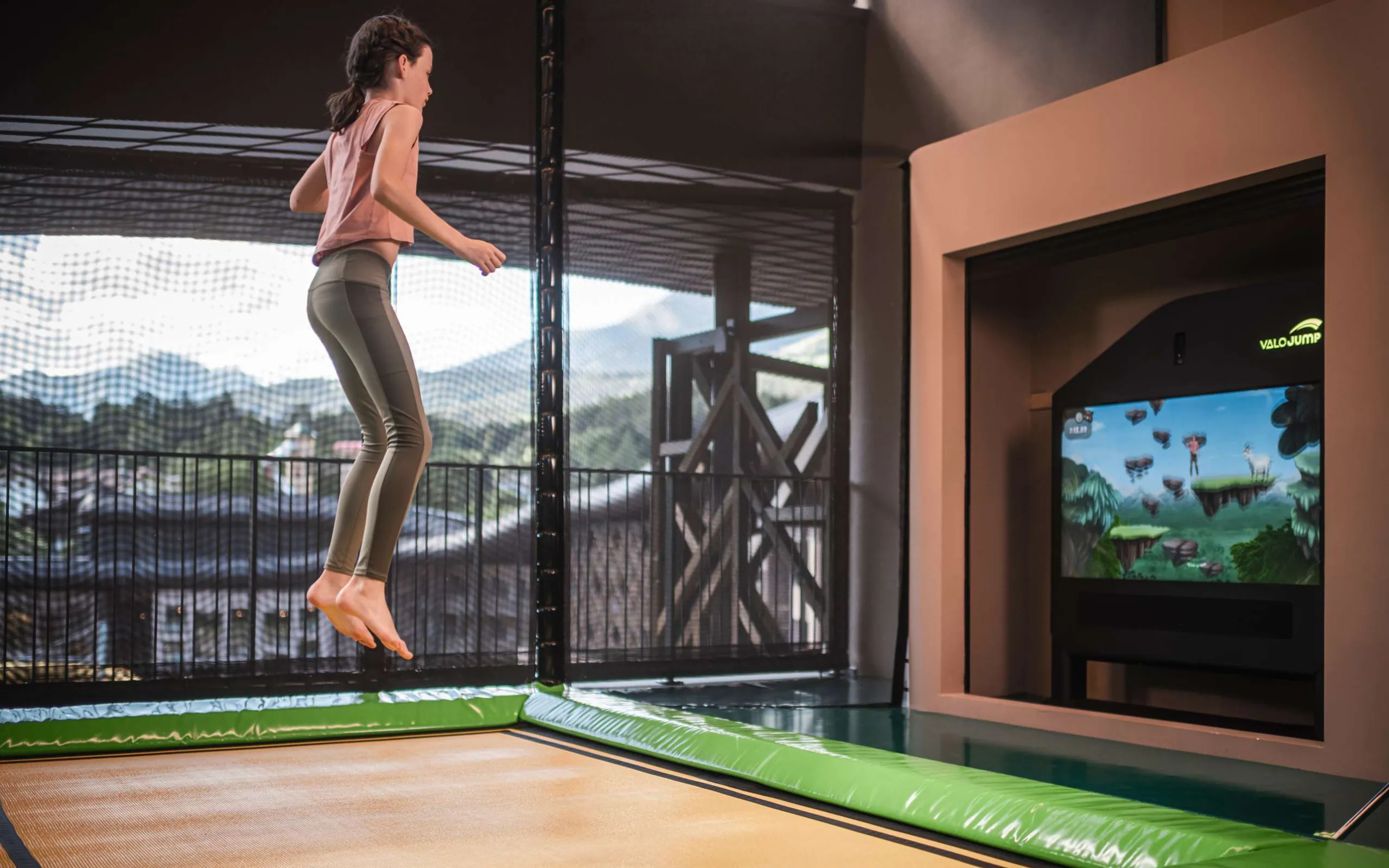 Junges Mädchen springt auf einem Trampolin und spielt damit das interaktive Spiel Valo Jump