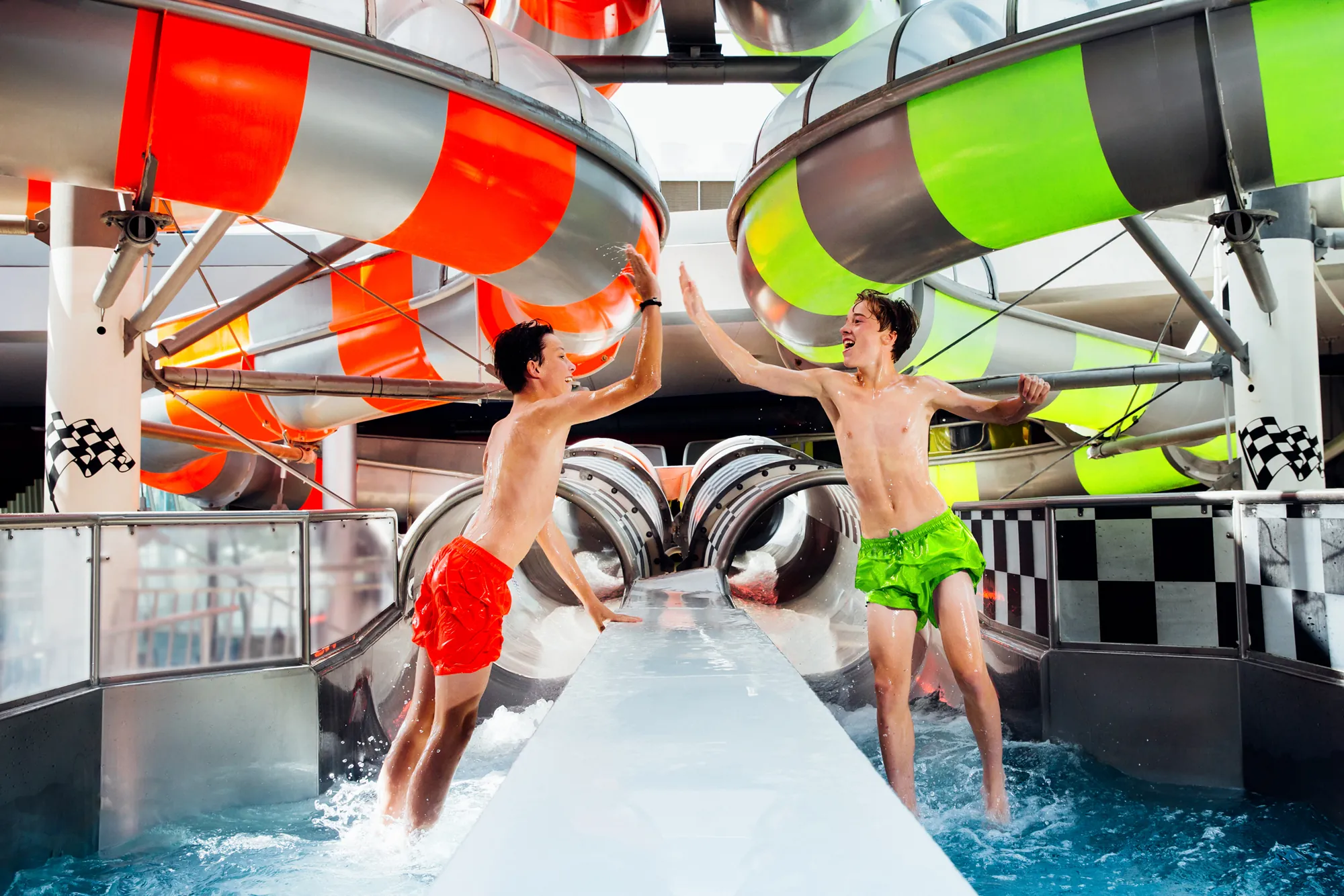 Zwei Jungen vor der Speedrutsche in der Therme Erding geben sich ein High five