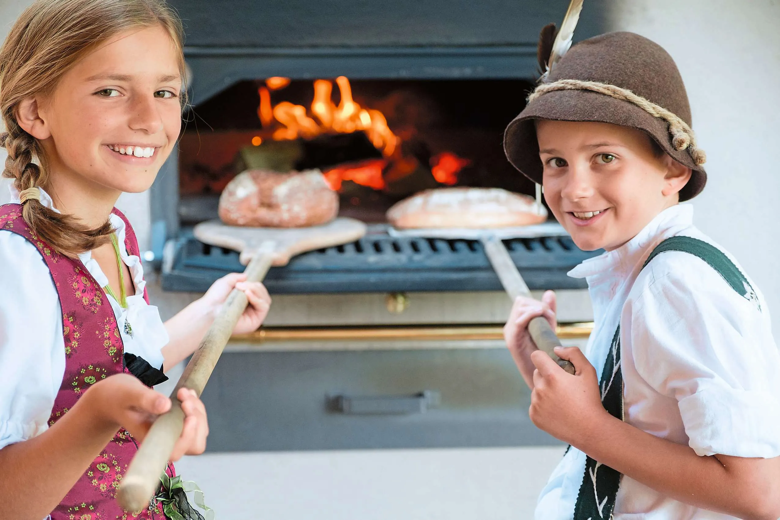 Zwei Kinder beim Brotbacken im Rahmen des Alpranger-Ferienprogramms im Sonnenalp Resort