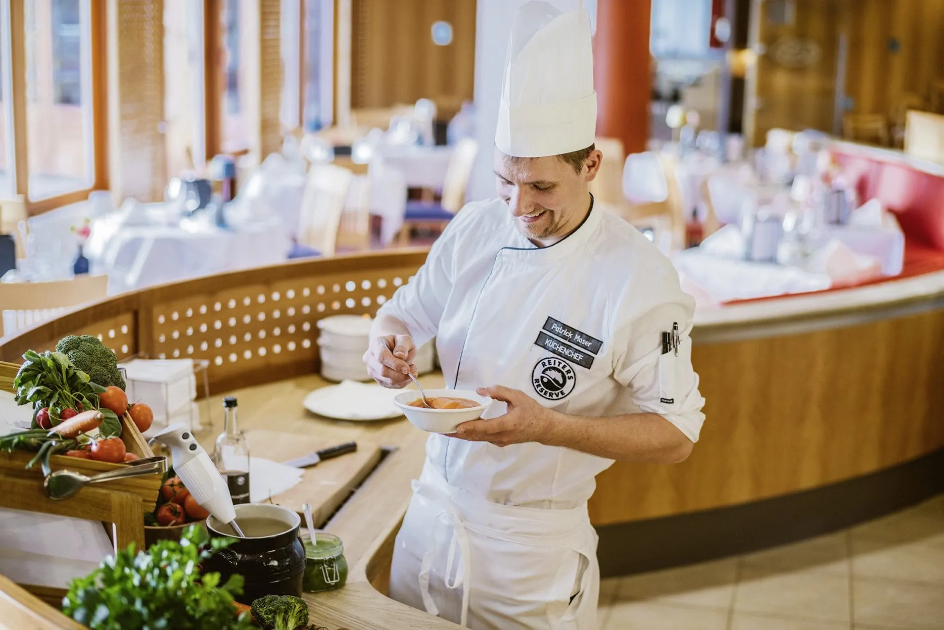 Koch mit Babybrei am Buffet im Familienhotel Reiters Finest Family Hotel