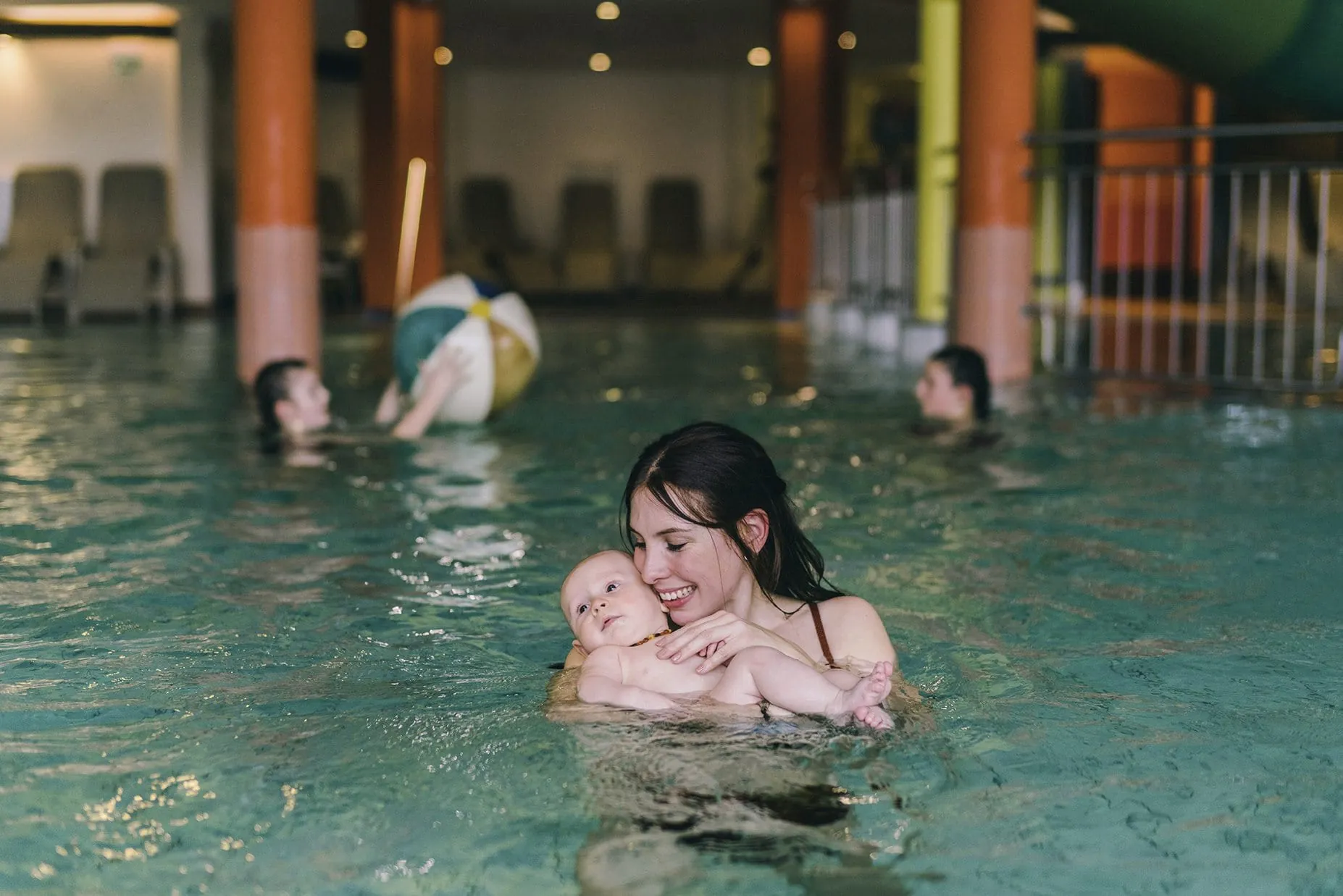 Mutter mit Baby beim Babyschwimmen im Pool des Reiters Finest Family Hotel