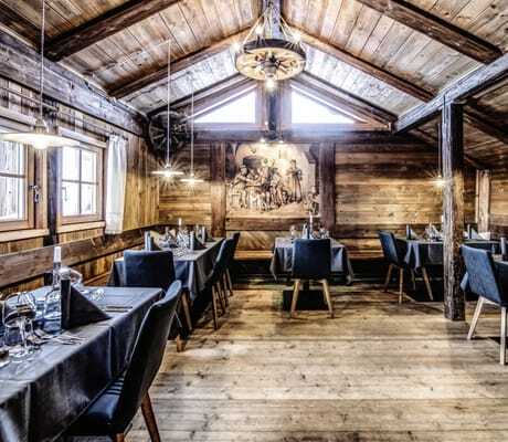 Historische Almhütte mit eingedeckten Tischen für die Gäste des Chalet Stern