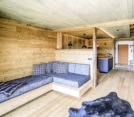 Blick in das Erdgeschoss des Chalet Stern mit Sitzecke, Küche und Treppe in das Obergeschoss