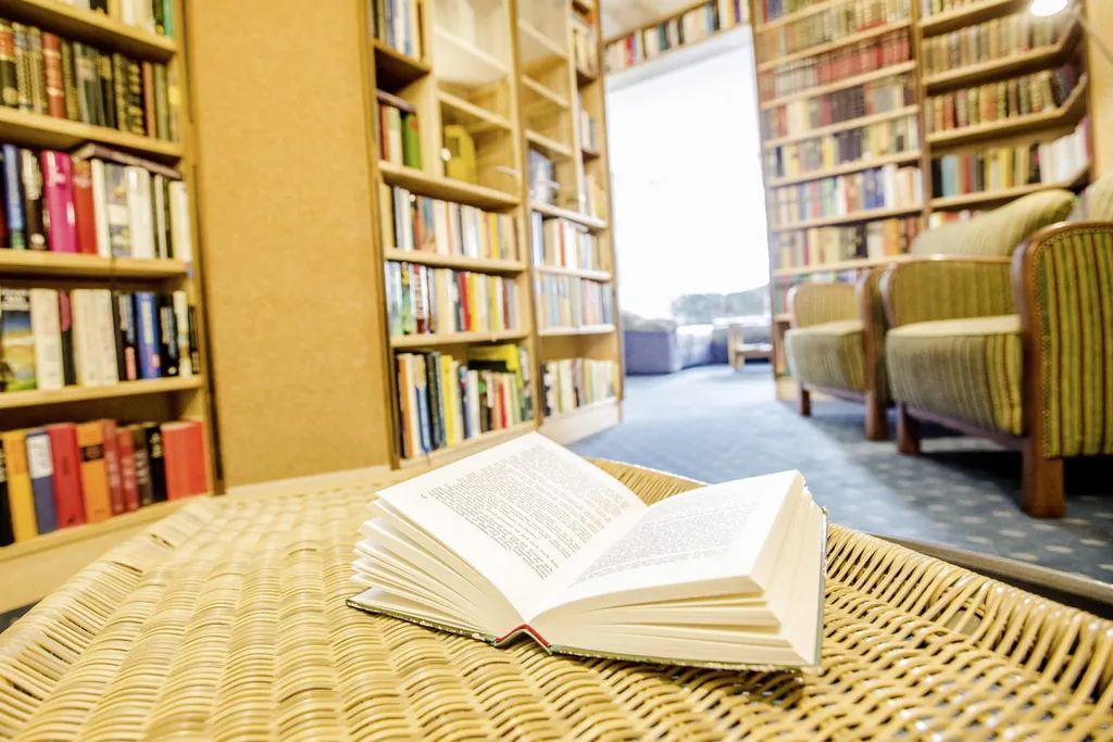 Bibliothek mit aufgeschlagenem Buch im Chalet Landhotel Haus Waldeck