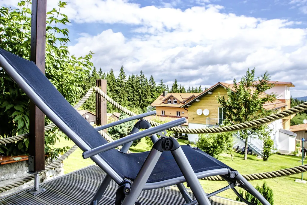 Balkon mit Liegestuhl und Blick &uuml;ber die Anlage des Chalet Landhotel Haus Waldeck