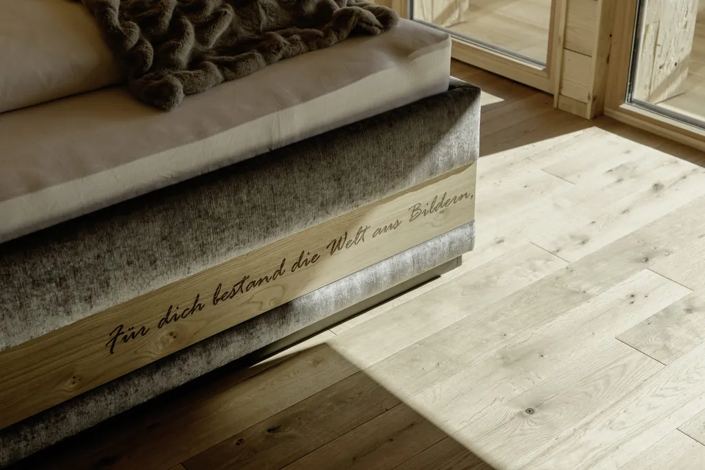 Geschnitztes Zitat im Bettrahmen "F&uuml;r Dich bestand die Welt aus Bildern" (Hesse, Narziss und Goldmund) der Hygna Chalets
