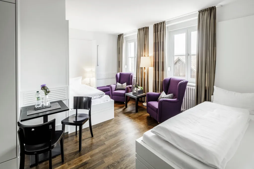 Elegantes Zimmer mit lila Ohrensesseln der KurOase im Kloster