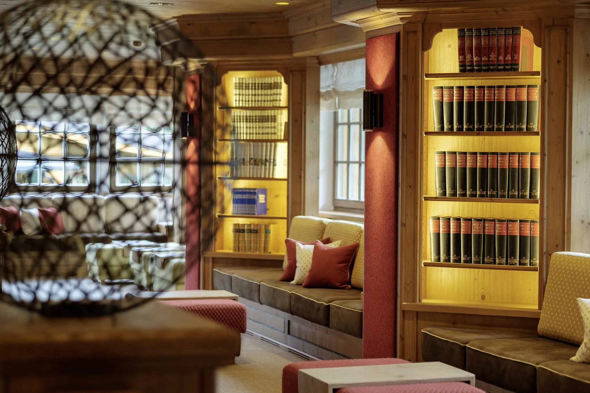 Biblithek mit beleuchteten Holzregalen der Kili-Galerie des Sonnenalp Resort