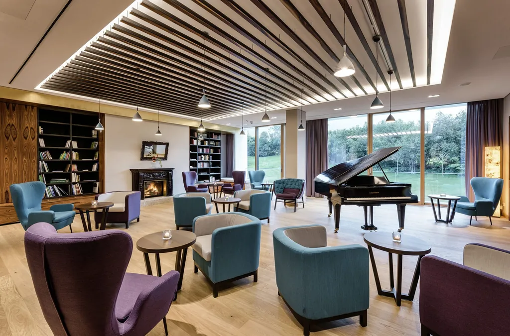 Bibliothek LiterArt mit Piano und offenem Kamin des Klosterhof Alpine Hideaway & Spa