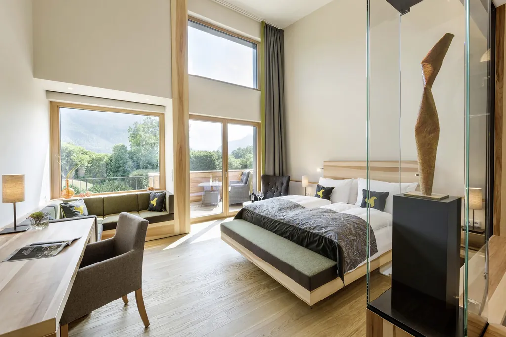 Helles Balkonzimmer mit Holzskulptur des Klosterhof Alpine Hideaway & Spa