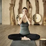 Frau in Yoga-Haltung im Yoga-Raum des Yoga-Hotels HUBERTUS MOUNTAIN REFUGIO ALLGAU