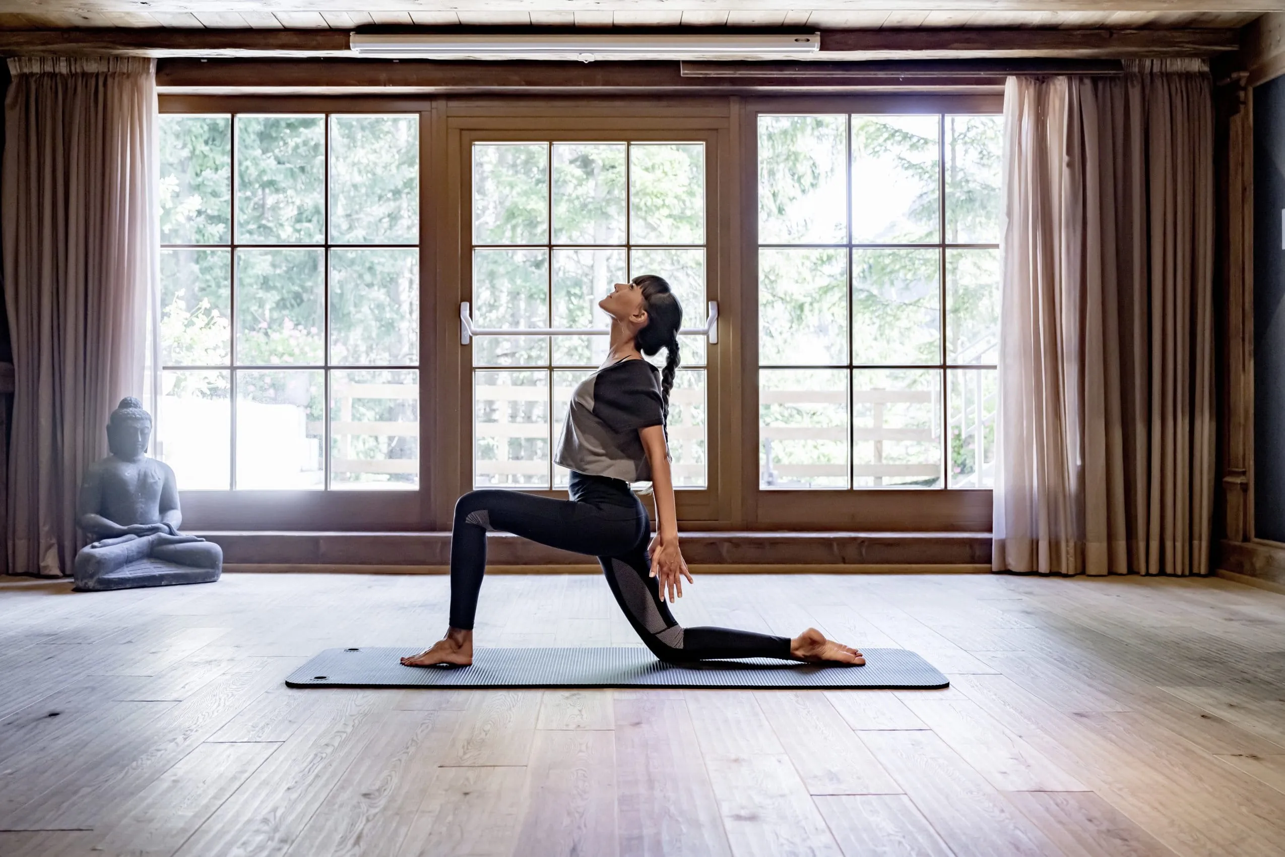 Frau in einer knienden Yoga-Pose im Yoga-Raum des Yoga-Hotels Naturhotels L&auml;rchenhof