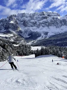 Skifahrer wedelt Piste hinunter in den Dolomiten