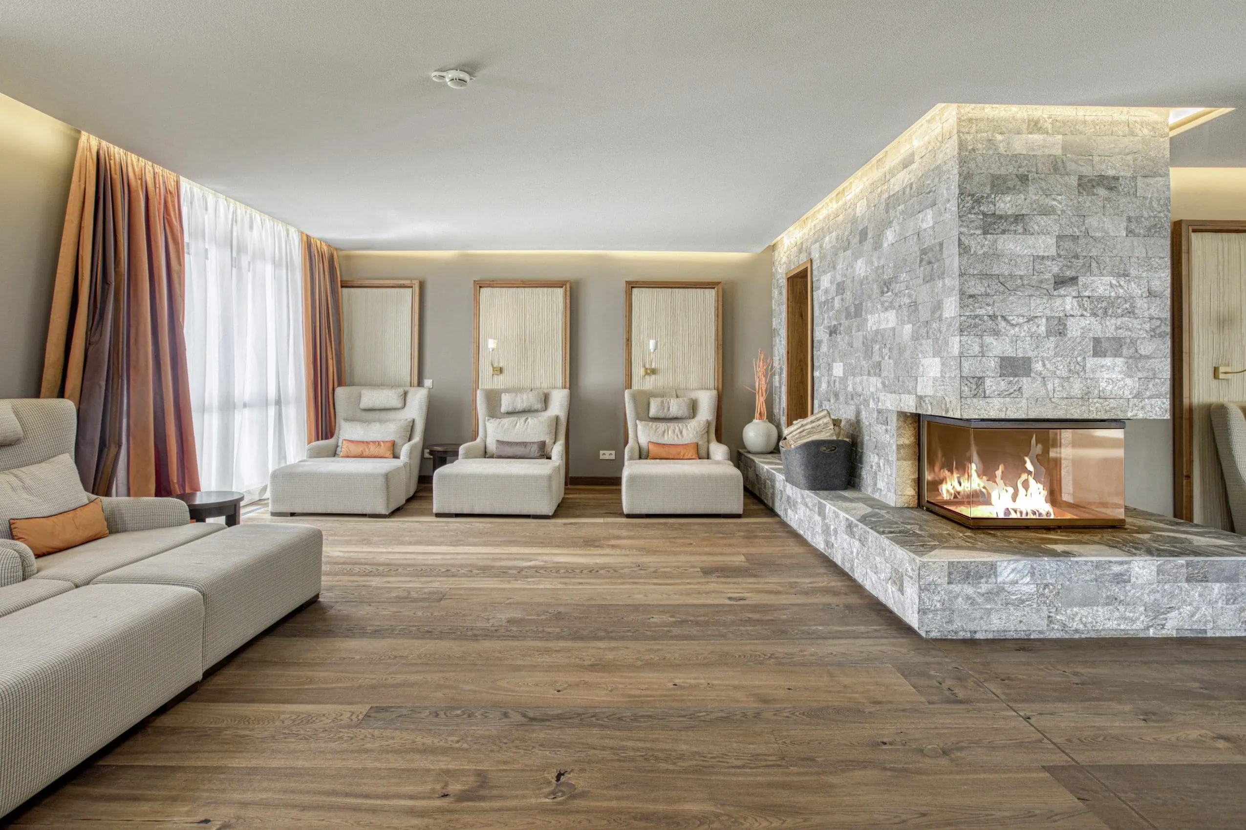 Ruheraum mit Liegesesseln und flackerndem Kamin im Wald- & Schlosshotel Friedrichsruhe