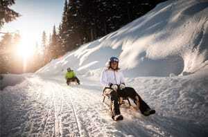 Zwei Rodler fahren die längste Winterrodelbahn Italiens auf dem Rosskopf hinab