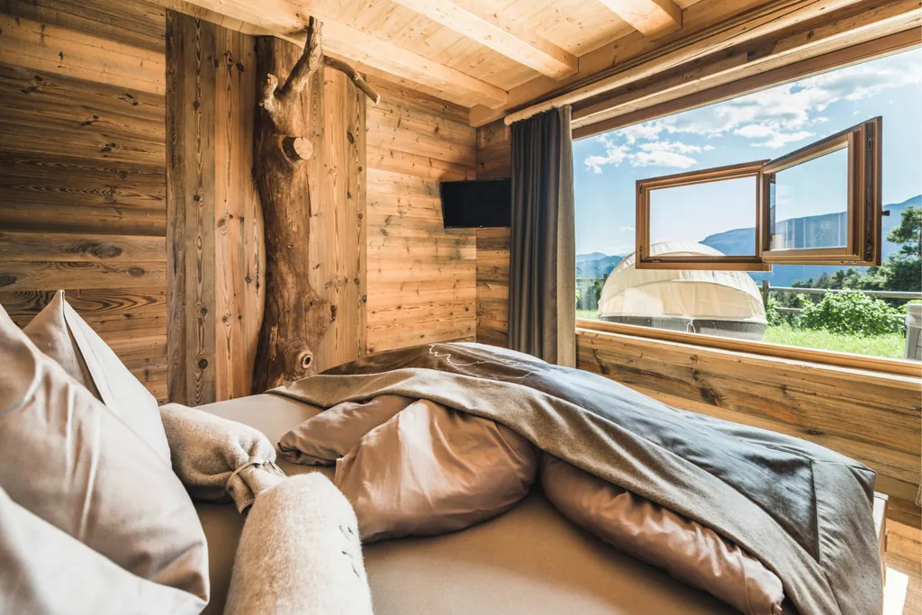 Blick aus dem gemütlich eingerichteten Schlafzimmer im Chalet Resort ZU KIRCHWIES in Südtirol