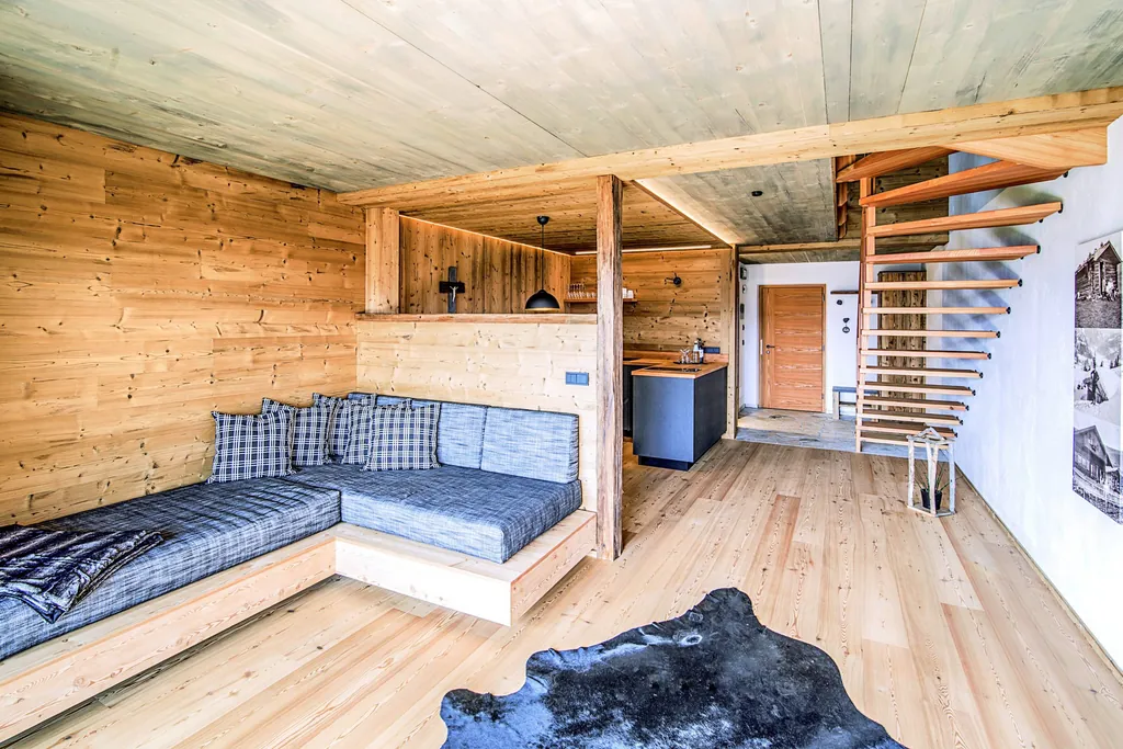 Blick in das Innere des Chalet Stern mit Sitzecke, Kochbereich und Treppe in den zweiten Stock