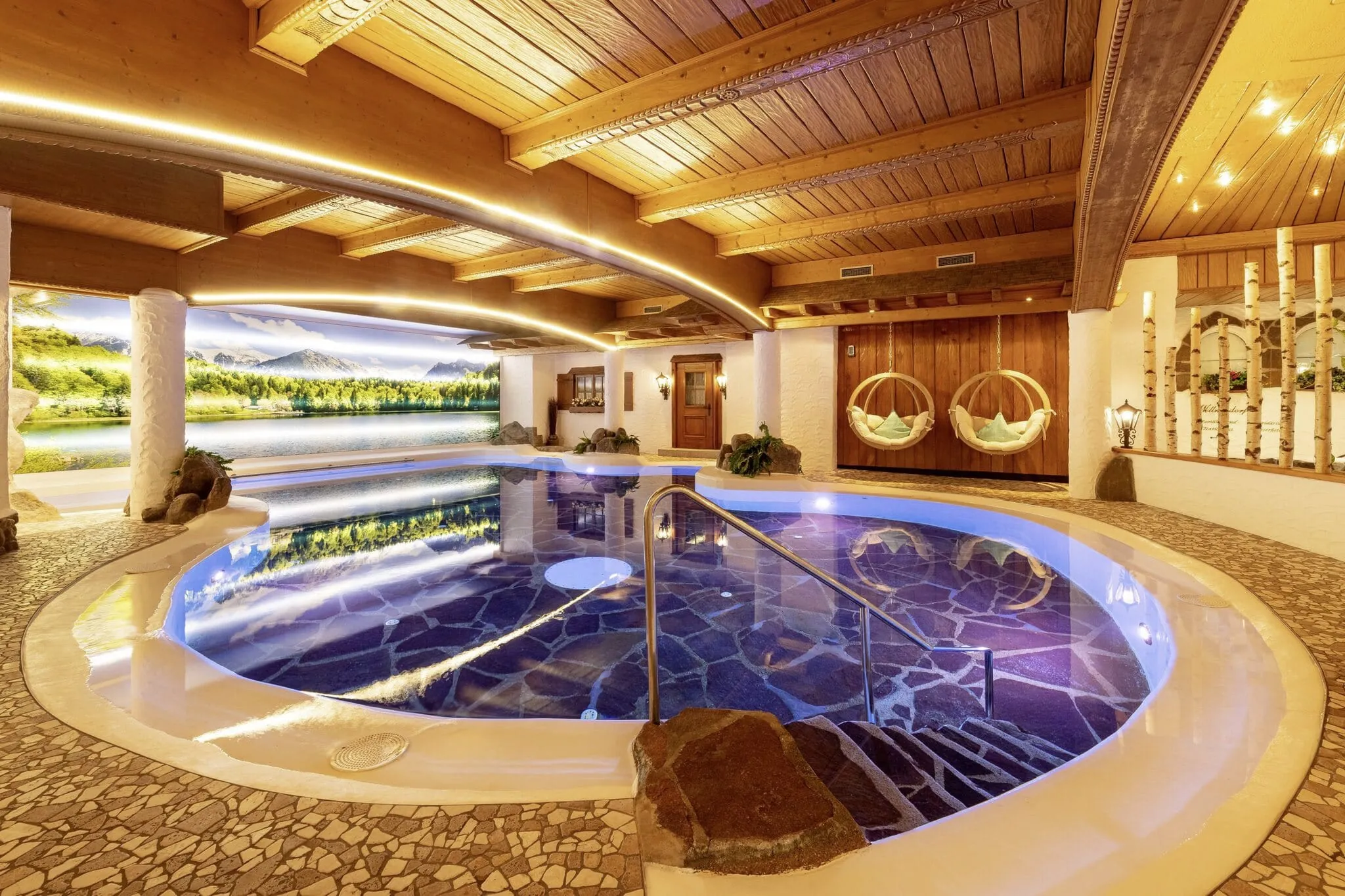 Rundlich gebauter Indoorpool im Parkhotel Burgm&uuml;hle mit stilvollen Lichtelementen