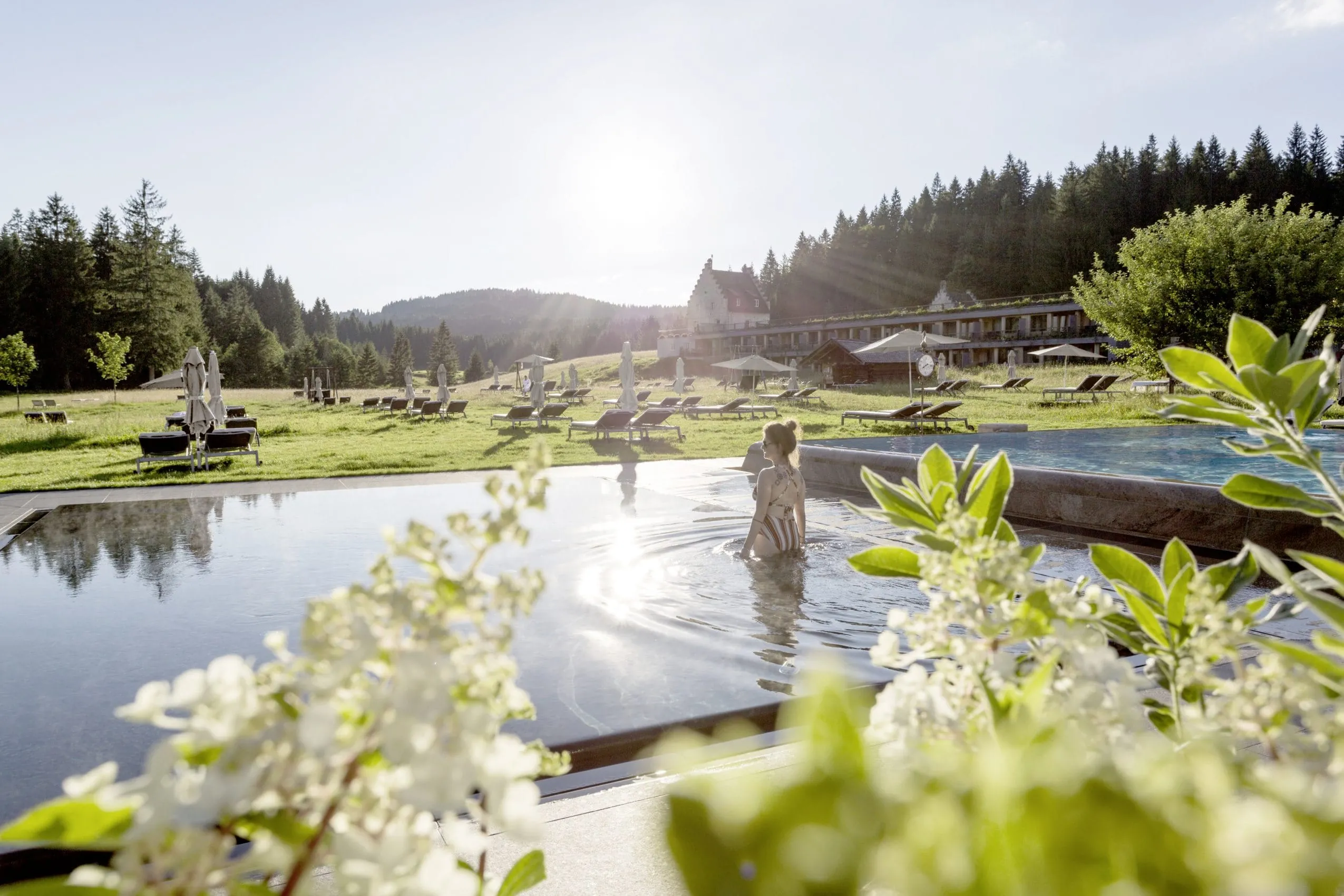 Frau badet im Au&szlig;enpool des Luxus-Wellnesshotels Das Kranzbach Hotel & Wellnessrefugium in Deutschland