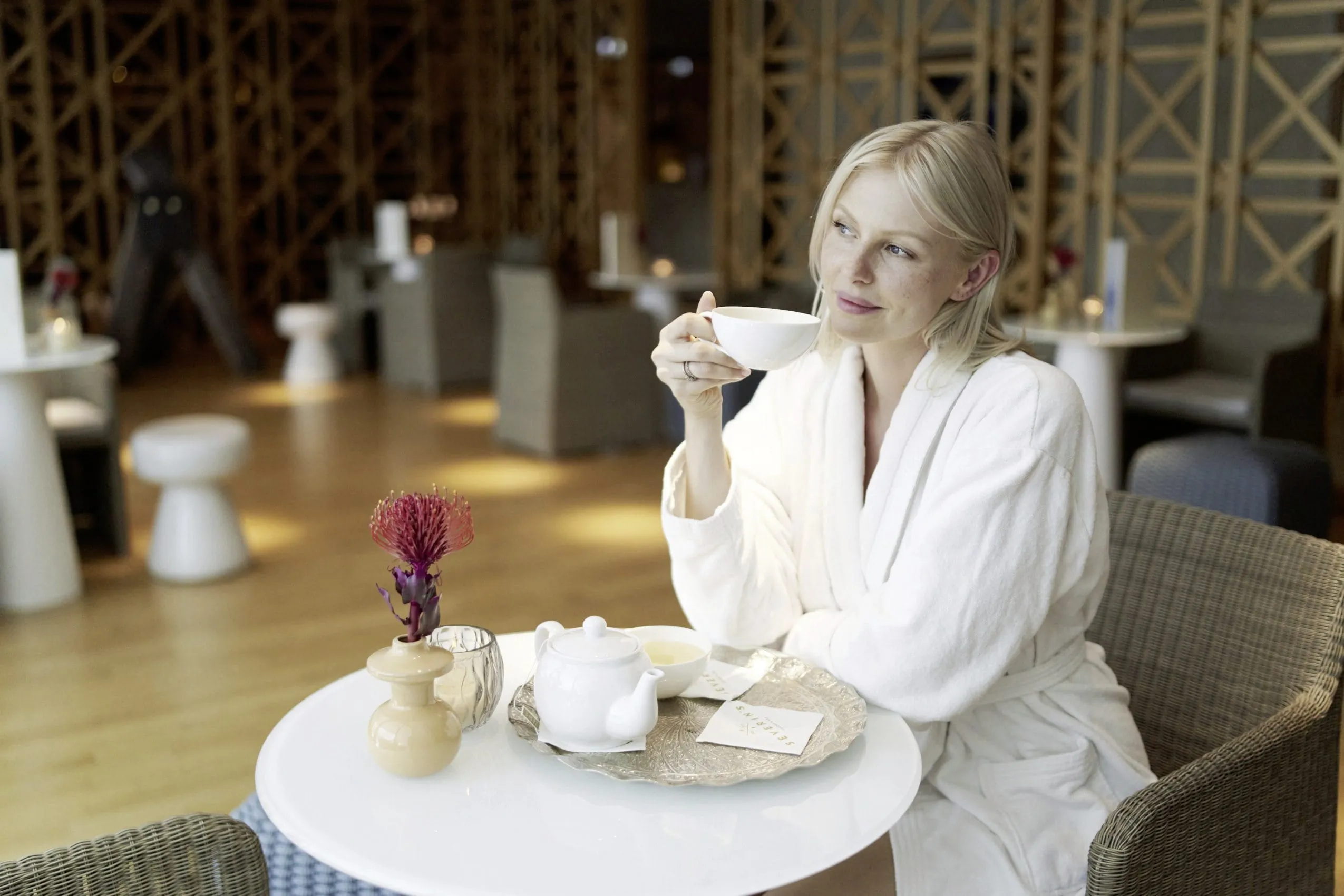 Junge Frau mit Teetasse im Ruhebreich des Spas des Luxushotels Severin*s Resort & Spa
