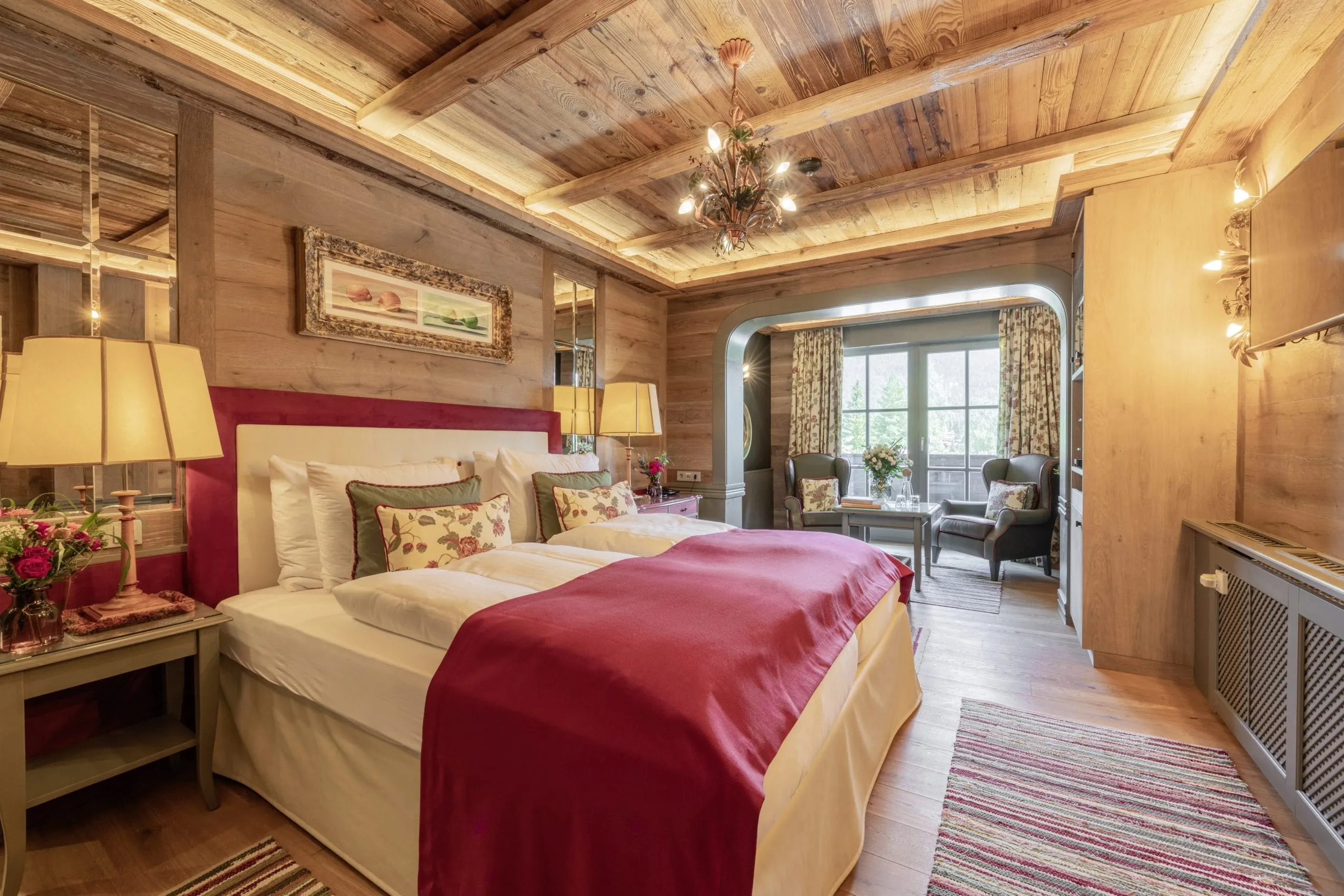 Doppelzimmer mit roter Tagesdecke im Luxus-Wellnesshotel Alpin Resort Sacher in &Ouml;sterreich