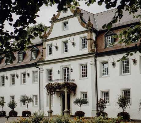Schlossfassade des Wald- & Schlosshotel Friedrichsruhe mit AMG vor der Tür