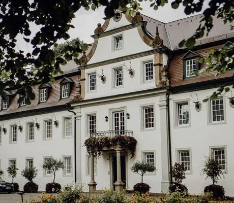 Schlossfassade des Wald- & Schlosshotel Friedrichsruhe mit AMG vor der Tür